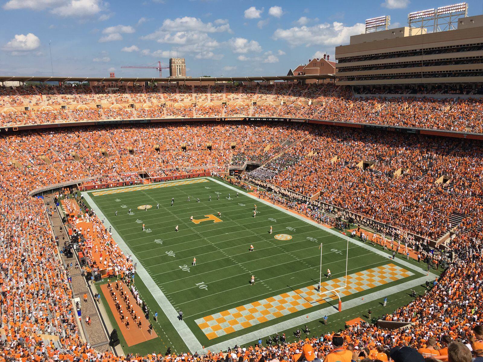 A packed college football stadium dressed in Tennessee orange on a sunny fall Saturday
